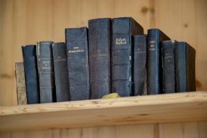 a row of books sitting on a shelf at Gasthof Wunder in Auna di Sotto