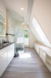 eine Küche im Dachgeschoss mit weißen Schränken und einem Fenster in der Unterkunft Villa Vivaldi in Kühlungsborn