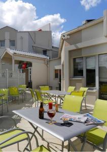 - une table et des chaises sur le toit-terrasse dans l'établissement Ibis Le Havre Sud Harfleur, à Harfleur