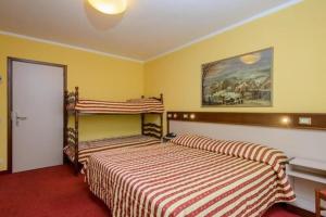 a bedroom with two beds and a painting on the wall at Bes Hotel Papa San Pellegrino Terme in San Pellegrino Terme
