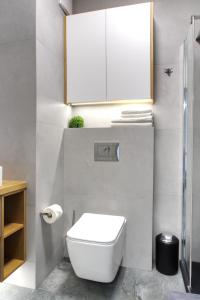 a bathroom with a white toilet and a cabinet at Essence Apartments Sapphire in Poznań