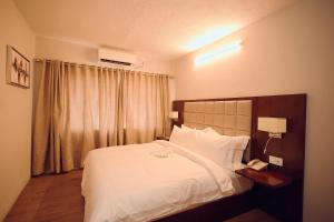ein Hotelzimmer mit einem Bett und einem Telefon in der Unterkunft Hotel King's Palace in Lubumbashi