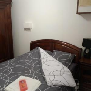 a bed with a gray and white comforter at marie-Emma wifi gratuite in Beaulieu-sur-Loire