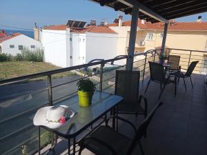 patio con mesa y sillas en el balcón en Villa Pandora, en Limenaria