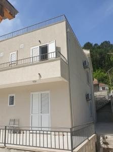 Un grand bâtiment blanc avec balcon est disponible. dans l'établissement Apartmani Zlatko, à Zelenika