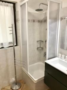bagno con doccia, vasca e lavandino di Il Ciottolo Apartments a Malcesine