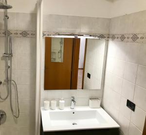 bagno con lavandino e specchio di Il Ciottolo Apartments a Malcesine