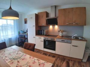 una cocina con armarios blancos y una mesa con comedor. en Ferienwohnung Brälu en Friedensdorf