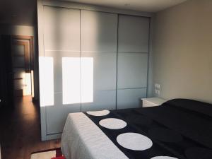 a bedroom with a black and white bed and a window at Apartamento en Rianxo in Rianjo