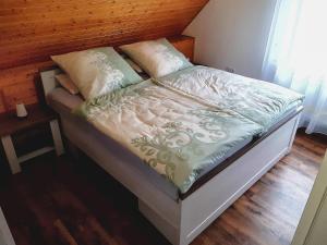 Bett mit einem Kopfteil aus Holz und Kissen darauf in der Unterkunft Ferienwohnung Brälu in Friedensdorf