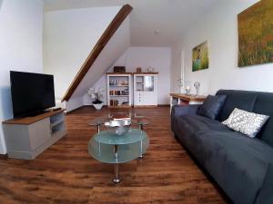 ein Wohnzimmer mit einem Sofa und einem TV in der Unterkunft Ferienwohnung Brälu in Friedensdorf