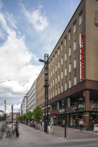 a building on a street with people walking past it at Omena Hotel Tampere in Tampere