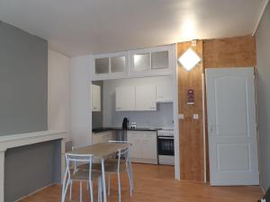 a kitchen with a table and chairs in a room at Appartement VanSuly in Salins-les-Bains