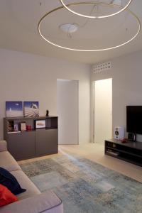 a living room with a couch and a chandelier at Casa da Gio', incantevole, nel cuore di Alba, con posto auto gratuito. in Alba