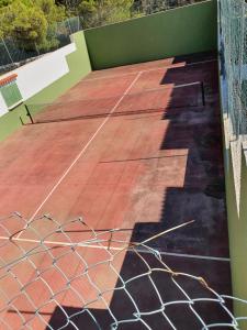 una pista de tenis con red en una pista en Casa Pelícano en Son Parc