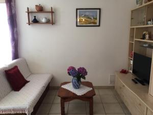 ein Wohnzimmer mit einer Blumenvase auf dem Tisch in der Unterkunft Rez de Villa Vue Mer Panoramique in Furiani