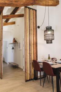 comedor con mesa y lámpara de araña en Apartaments la rambla - Garnatxa - 4 persones, en Cornudella