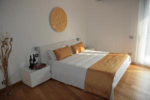 una camera con un grande letto bianco e un pavimento in legno di Mareneve Resort a Linguaglossa
