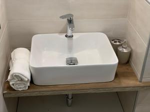 een witte wastafel op een houten plank in een badkamer bij Girasole in Trento