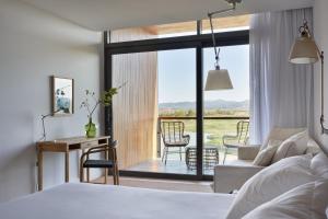 a bedroom with a bed and a living room with a view at Hotel Terraverda in Torroella de Montgrí
