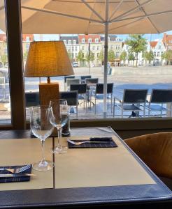 a table with two wine glasses and a lamp on it at Logies Graaf Van Vlaanderen in Bruges