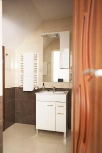 a bathroom with a white sink and a mirror at Zajazd Kresowia in Sokółka