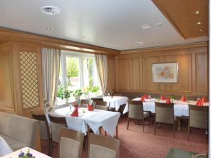 a restaurant with white tables and chairs and a window at Hotel Roshop in Barnstorf