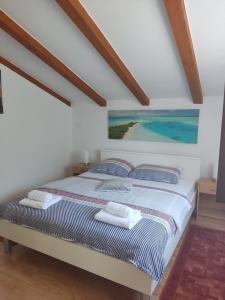 a bedroom with a bed with a painting on the wall at Apartment Ankica in Umag