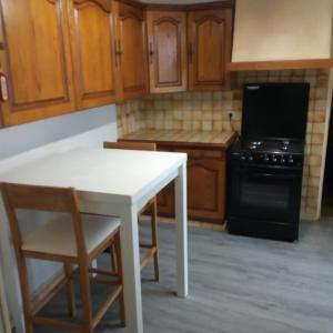 a kitchen with a white table and a stove at marie-Emma wifi gratuite in Beaulieu-sur-Loire