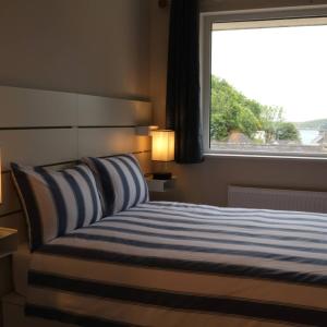 a bedroom with a bed with a large window at Crow's Nest Glandore - 1 - Self Catering in Glandore