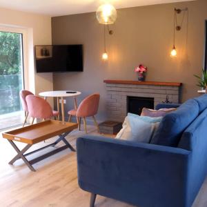 a living room with a blue couch and a fireplace at Crow's Nest Glandore - 1 - Self Catering in Glandore