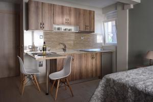 a kitchen with a sink and two chairs next to a bed at Haus Viktoria 1 in Limenas