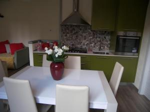 una cocina con una mesa blanca con un jarrón de flores. en Casa Molinari en Como