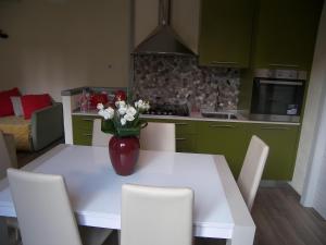 una cocina con una mesa blanca con un jarrón de flores. en Casa Molinari, en Como 3 fotos más