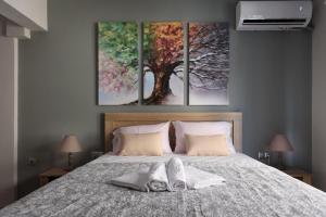a bedroom with a bed with three paintings on the wall at Haus Viktoria 1 in Limenas