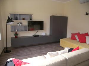 Una sala de estar con un sofá y un televisor de pantalla plana. en Casa Molinari, en Como