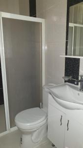 a white bathroom with a toilet and a sink at Sky Ankara Big Suit Home in Ankara