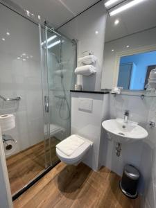 a bathroom with a toilet and a sink and a shower at Hotel Golfzicht in Noordwijk aan Zee +45 photos