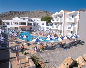 a group of people sitting around a pool at a hotel at Lindia Thalassa in Pefki