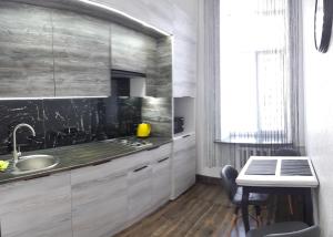 LUX Apartments في فينيتسا: مطبخ مع حوض ومكتب مع طاولة