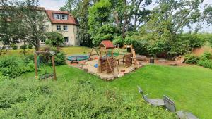 un patio trasero con un parque infantil con un juego de juegos en Parkhotel Diani, en Leipzig
