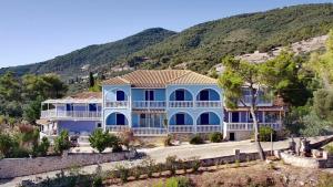 a large blue house with a mountain in the background at Villa Bella Vista in Marathias