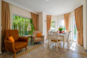 een woonkamer met een eettafel en stoelen bij Infinity Beyaz Villa in Fethiye