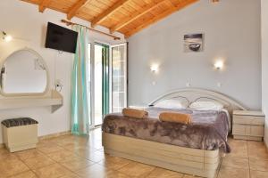 a bedroom with a bed and a tv on the wall at Fotini Studios in Paleokastritsa
