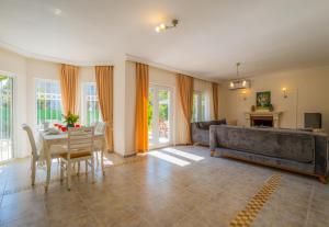 een woonkamer met een bank en een tafel bij Infinity Beyaz Villa in Fethiye