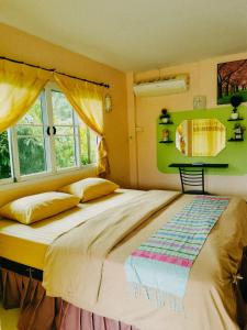 - une chambre avec un grand lit et une fenêtre dans l'établissement ภูร์ชรินท์ รีสอร์ท, à Ban Than Phra