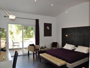 a bedroom with a large bed and a balcony at Private Hôtel - Adult Only in Porto-Vecchio