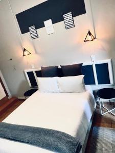Un dormitorio con una gran cama blanca y una mesa en VnA Guesthouse, en Newcastle