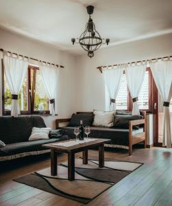 uma sala de estar com sofás e uma mesa de centro em Etno Garden Apartments em Plitvica selo