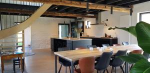 een keuken en eetkamer met een tafel en stoelen bij Huis van Silvie in Koolskamp